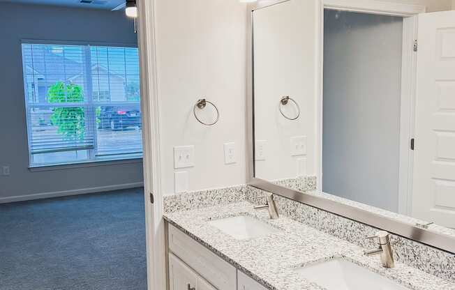 A bathroom with a large mirror and two sinks.