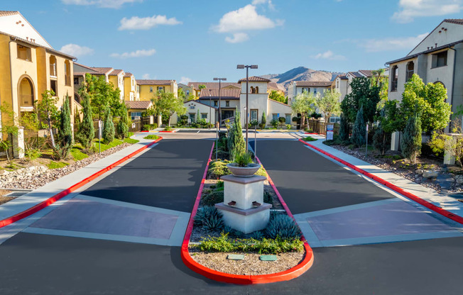 an empty street in a neighborhood with houses and plants on a cross walk