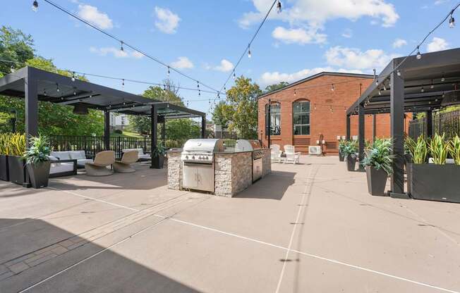 A patio area with a black awning and a brick building in the background.