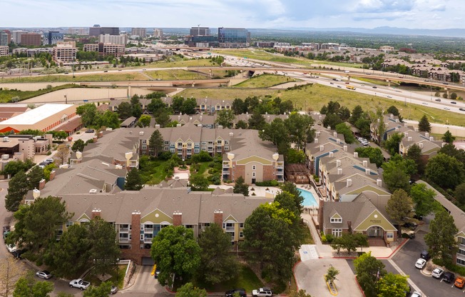 an aerial view of a neighborhood with houses and a city in the background