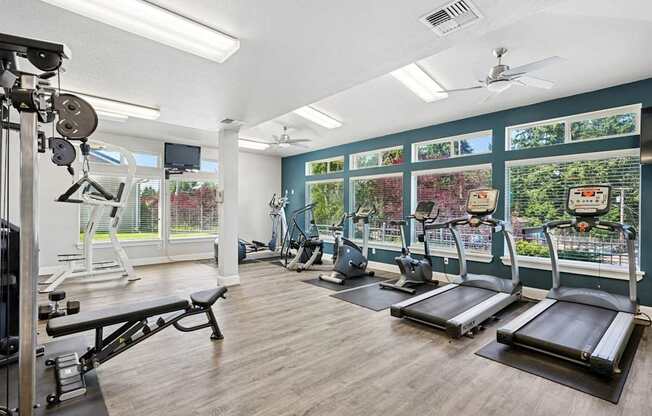 A gym with treadmills, weights, and exercise equipment at The Madison apartments in Olympia, WA