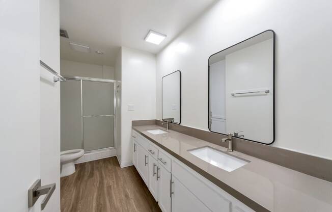 a white bathroom with two sinks and a shower