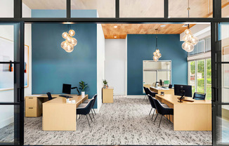 a large office with desks and chairs and a blue wall