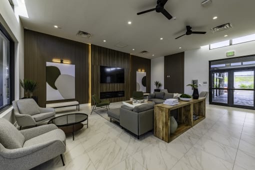 a living room with couches and chairs and a tv the gym  at a residential apartment community Resia in Decatur GA