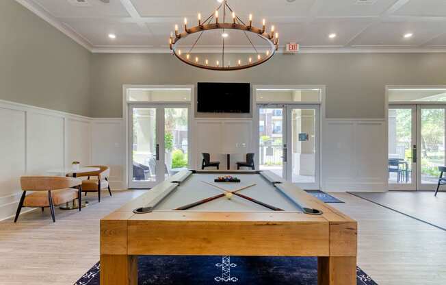 Resident Lounge with Pool Table and Ring Shaped Chandelier at Madison on the Meadow, Stafford, TX, 77477