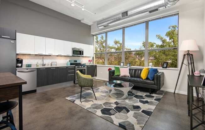 a living room with a kitchen and a large window