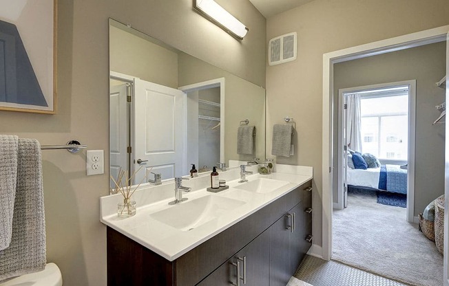 Bathroom with a large mirror and two sinks at Highgate at The Mile near Tysons Corner
