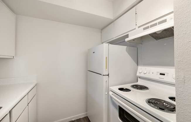 a kitchen with white appliances and a refrigerator