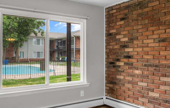 A room with a brick wall and a sliding glass door.