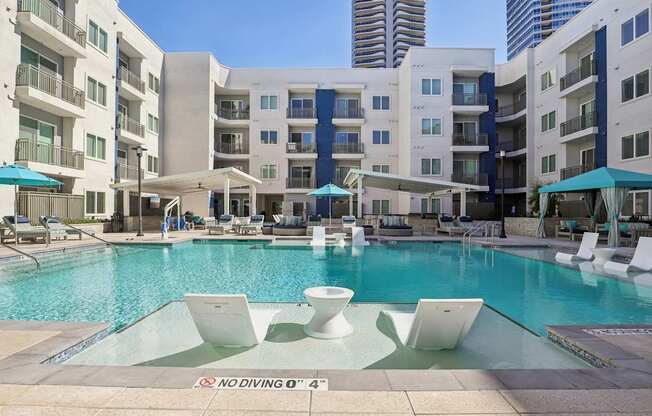 A pool surrounded by white chairs and umbrellas with a sign that says "No Diving".