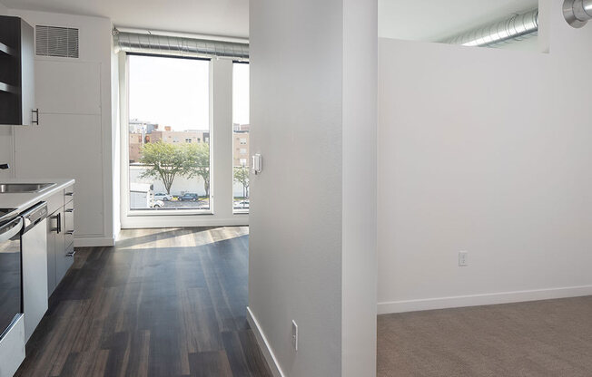 an empty kitchen and living room with a large window at The Landing at 1001 NP, Fargo, ND, 58102