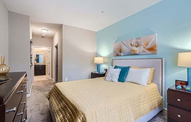 A bedroom with a large bed and a painting on the wall.