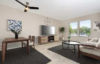 a living room with a ceiling fan and a television