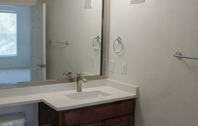 a bathroom with a toilet and a sink and a mirror