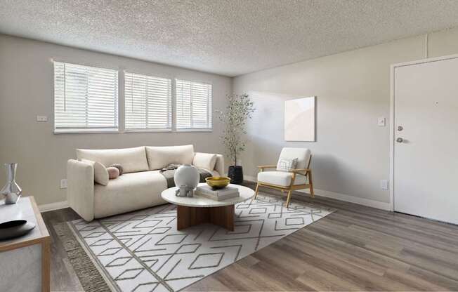 A living room with a white couch, a coffee table, and a chair.
