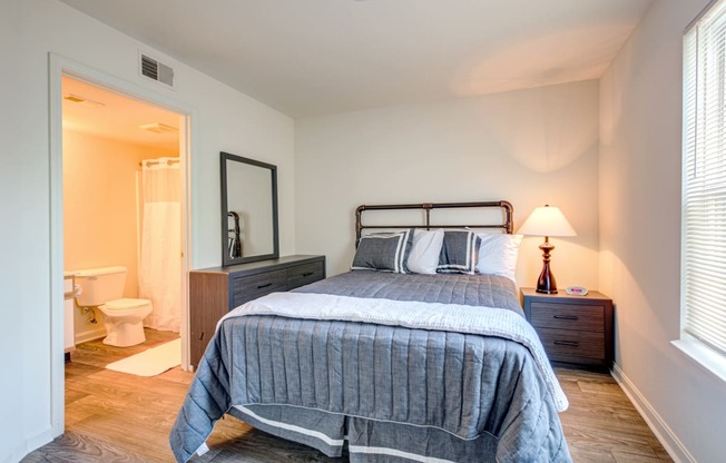 a bedroom with a bed and a bathroom with a toilet