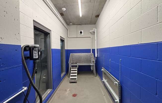 A blue and white hallway with a hose on the wall.