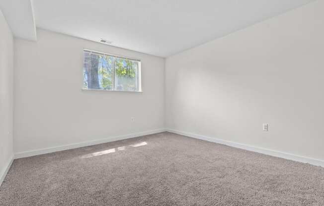 an empty room with carpet and a window