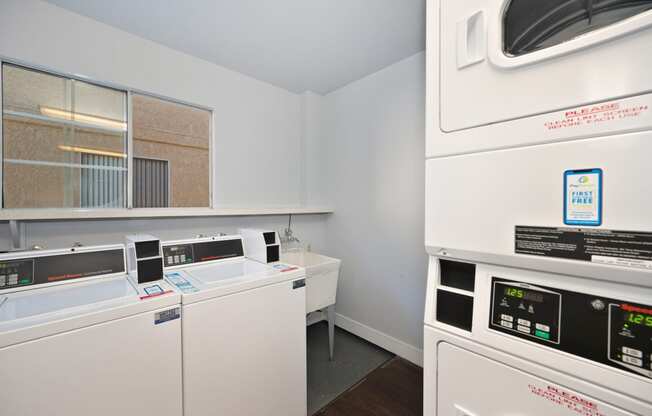 a laundry room with two washing machines and a sink