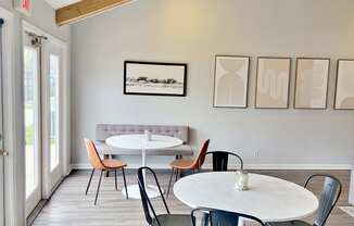 a dining room with tables and chairs and paintings on the wall