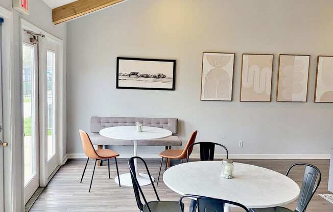 a dining room with tables and chairs and paintings on the wall