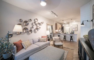 a living room with a white couch and a bar in the background