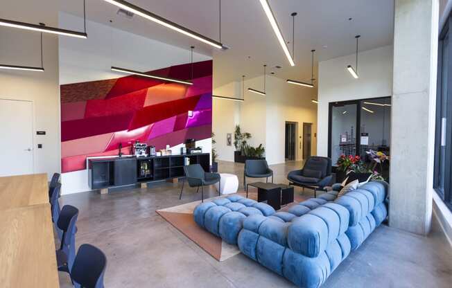 a large lobby with a blue couch and chairs at Analog PDX Apartments, Oregon