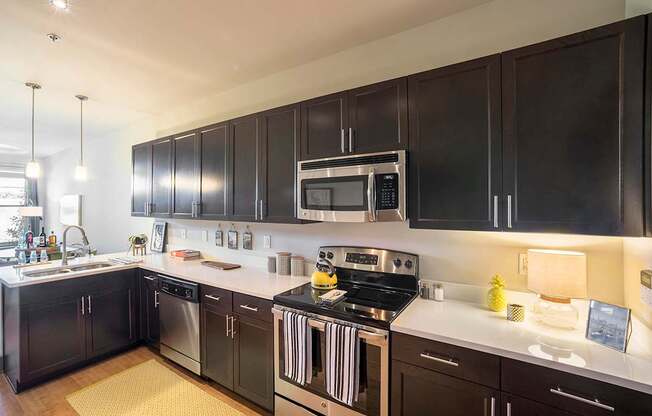 a kitchen with black cabinets and white countertops