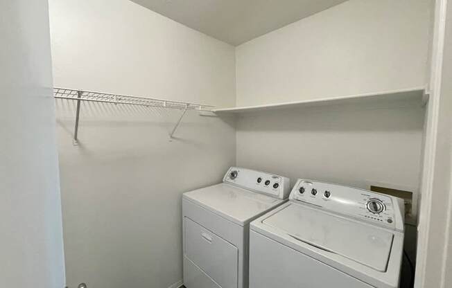 A small laundry room with a washer and dryer.