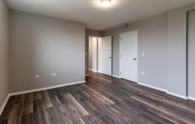 a living room with wood flooring and white walls and doors