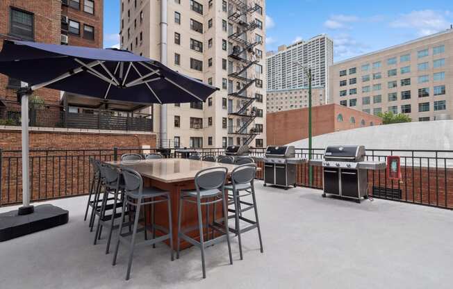 a patio with a table and chairs and a grill
