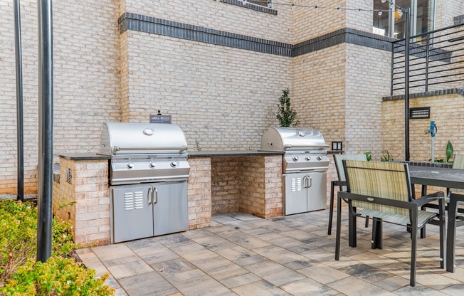 A patio with a grill and a bench.