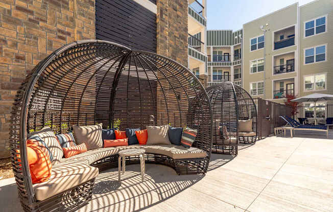 A large outdoor patio with a circular woven metal structure and a couch.