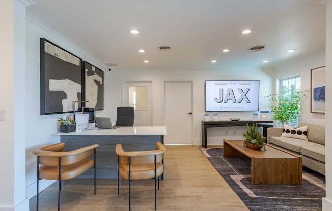 A modern living room with a wooden floor and a large screen displaying the word