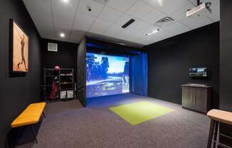 A multi-sport simulator projector screen in a community room with sports equipment.