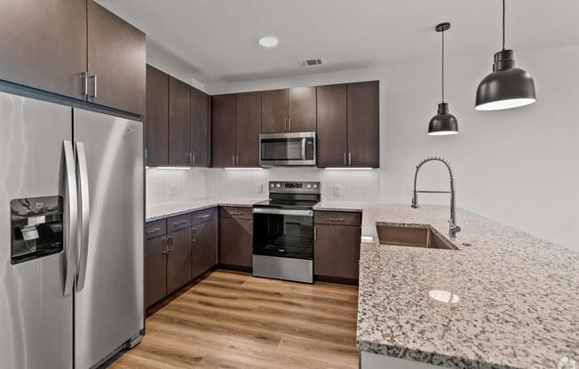 A modern kitchen with a refrigerator, microwave, oven, sink, and dishwasher. at Aurora Watson Branch, Texas, 76063