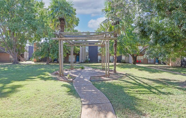 Lush trees and grass surround a paved gazebo at The Drake in Bossier City, LA
