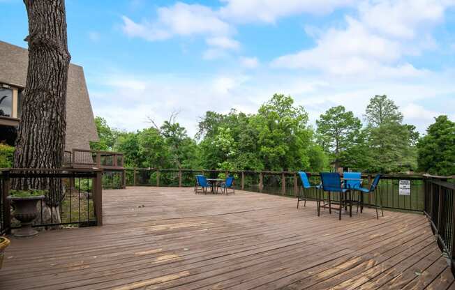 a deck with a tree and chairs on it