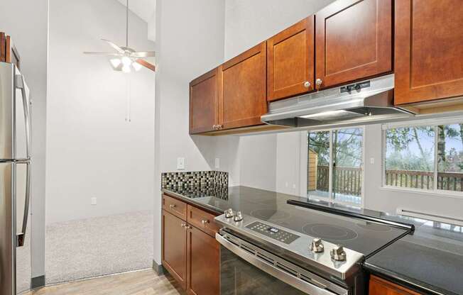 A kitchen with wooden cabinets and a stainless steel refrigerator.