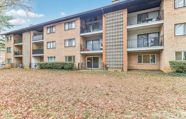 an exterior view of an apartment building with fallen leaves