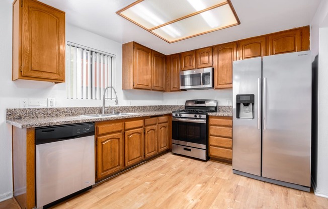 a kitchen with stainless steel appliances and wooden cabinets