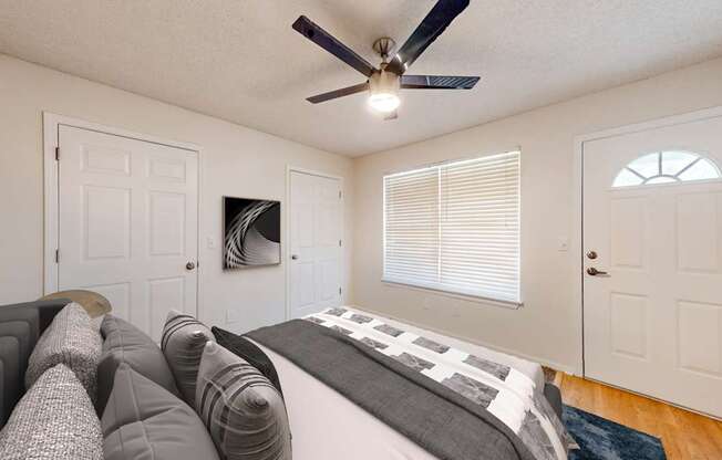 A bedroom with a bed, pillows, and a ceiling fan.