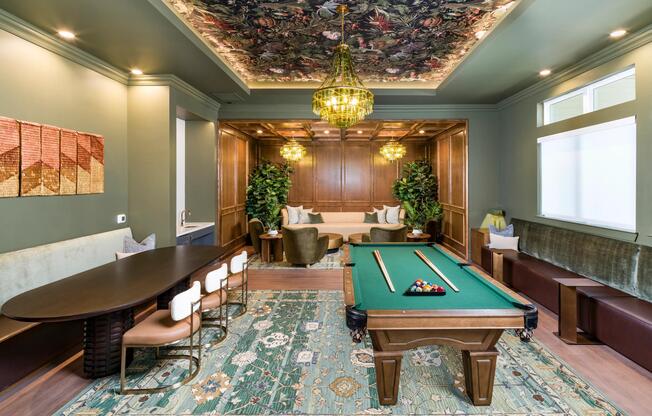 The Parlor features a billiards table, shared seating, and rich finishes set beneath a patterned ceiling and statement lighting.