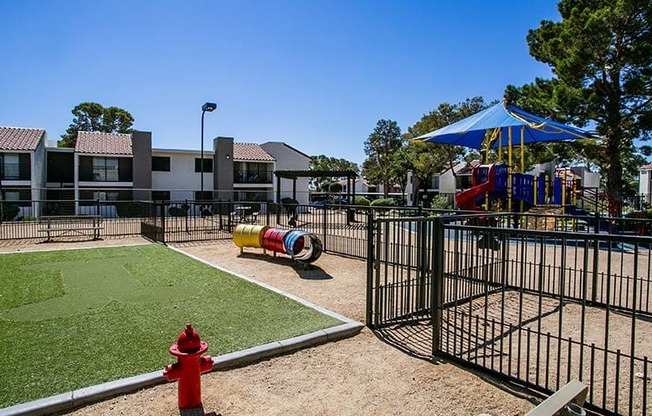 a fenced in play area with a red fire hydrant