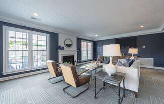 a living room with a white couch and chairs and a fireplace