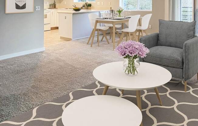 Open living room with sliding doors to a private balcony on left and kitchen in back. Staged with coffee tables, chair, dining set.at Sitka Heights, Washington