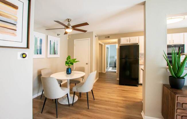 A dining room with a white table and chairs.