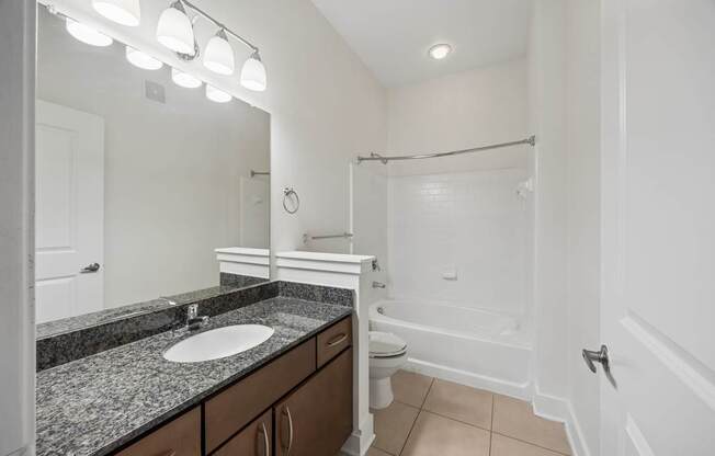 A bathroom with a sink, toilet, and bathtub.