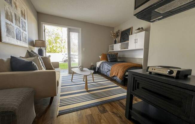 a bedroom with a bed and a living room with a couch and a tv