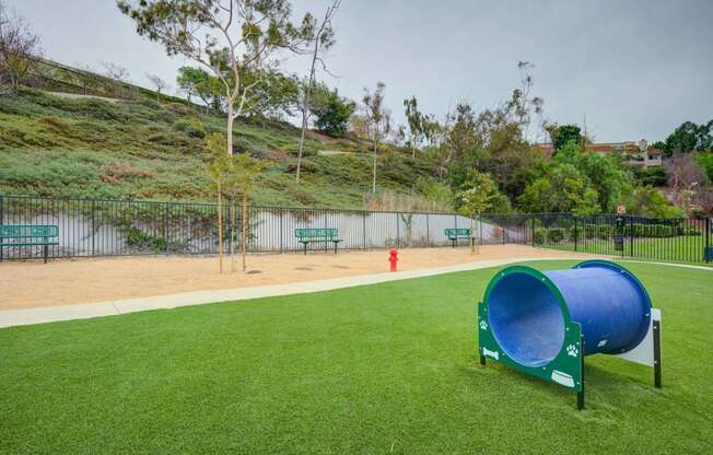 a dog park with a large blue dog kennel and a red fire hydrant  at Laguna Gardens Apts., California, 92677